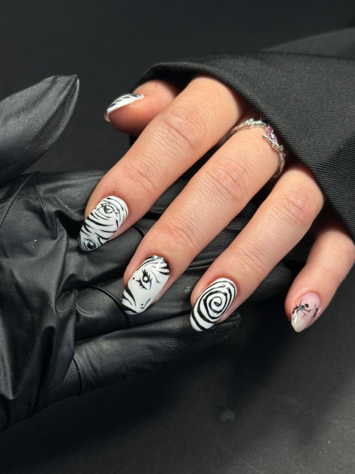Schwarz-weißes Nail Art mit surrealen Augen und Spiralen